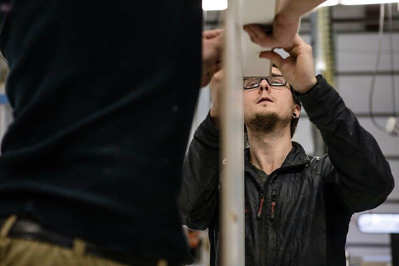 Two men working on custom display. In manufacturing warehouse.