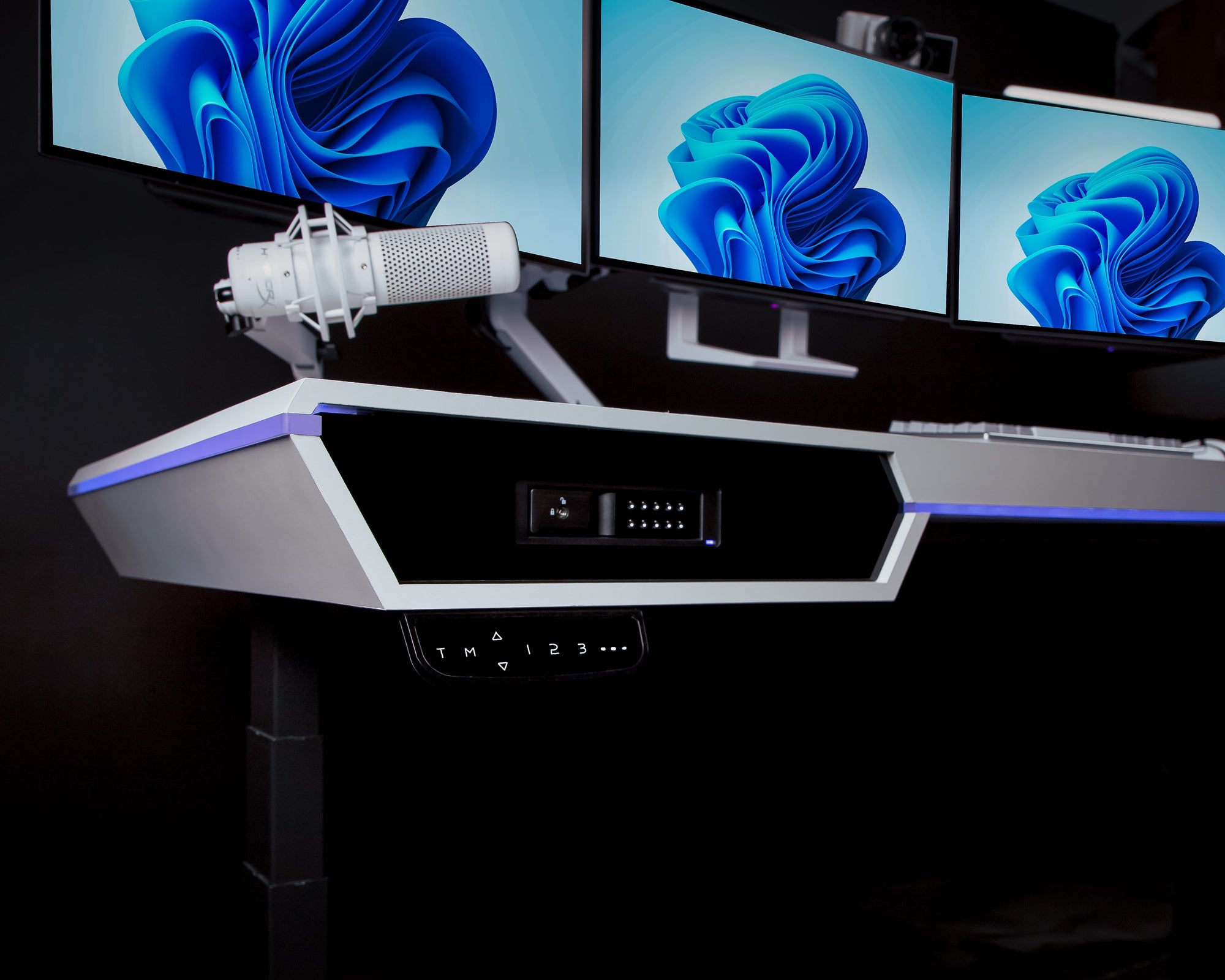 The Overkill Battle Station – Pedestal Source. Close up of the left side of the white laminate desk. you can see there are contols to adjust height of the desk. 